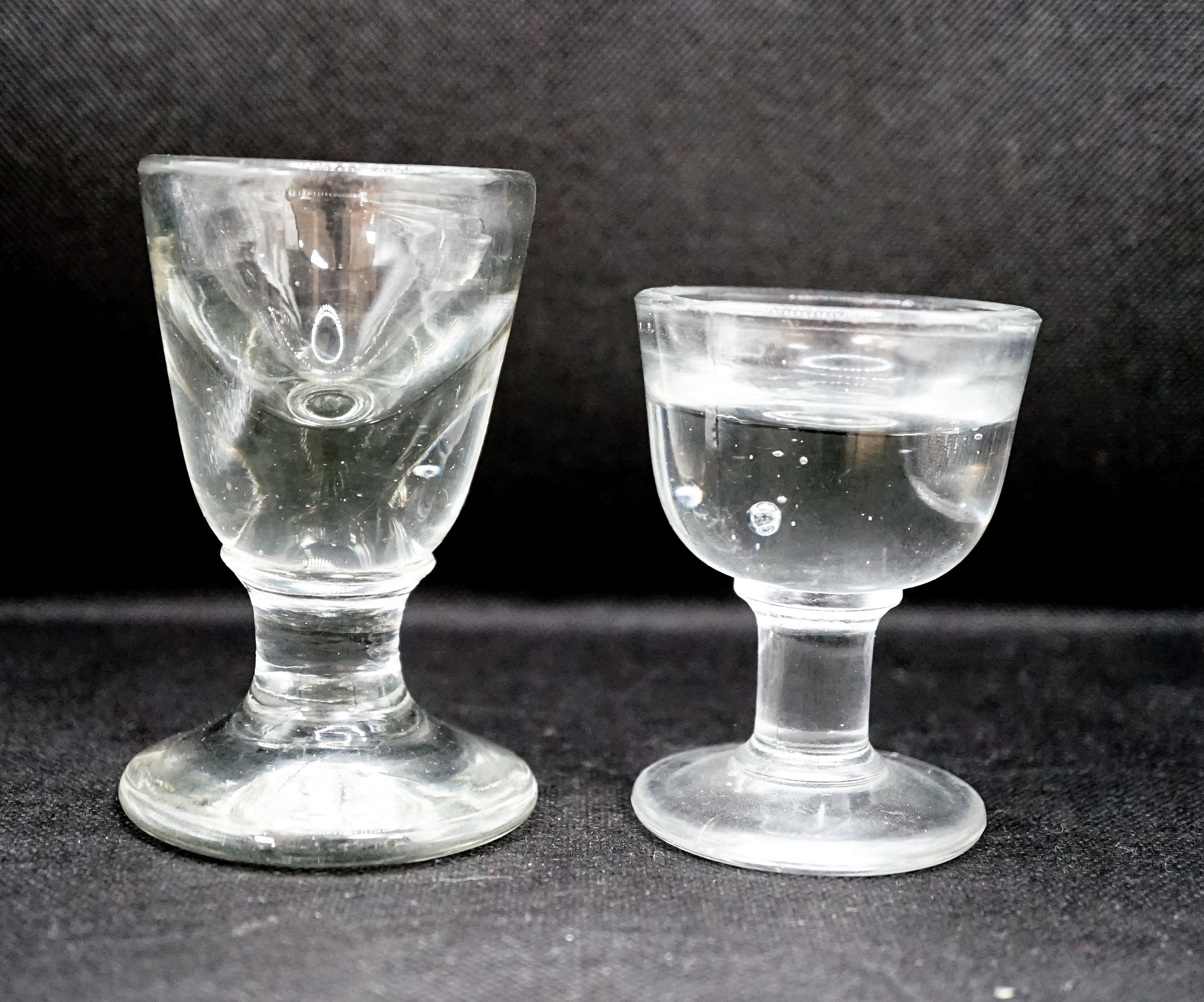 A Georgian deceptive Toastmasters glass and a later penny lick type glass, tallest 10 cm